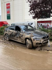 Na ulici zůstávají i poničená auta, některá voda doslova vymrštila na kapotu