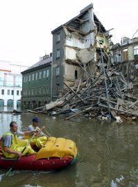 Záchranáři na člunu projíždějí kolem zřícené budovy v pražském Karlíně a hledají další lidi, kteří potřebují evakuovat, 15. srpna 2002.