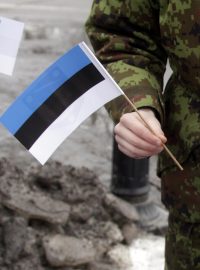 Voják rozdává na vojenské přehlídce v Narvě estonské vlaječky. Město Narva se nachází na hranici s Ruskem.