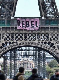 Příznivci hnutí Extinction Rebellion v neděli z Eiffelovy věže vyvěsili transparent s nápisem Rebel.