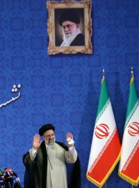Nový prezident Íránu Ebráhím Raísí na tiskové konferenci zdraví novináře s obrazem ajatolláha Alího Chameneího v pozadí