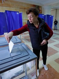 Žena vhazuje svůj hlas během světem neuznávaného referenda v Ruskem okupovaném Doněcku